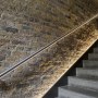 Residential apartment building atrium - Wapping High Street | Staircase, featuring hidden LED strip detail to highlight brickwork | Interior Designers